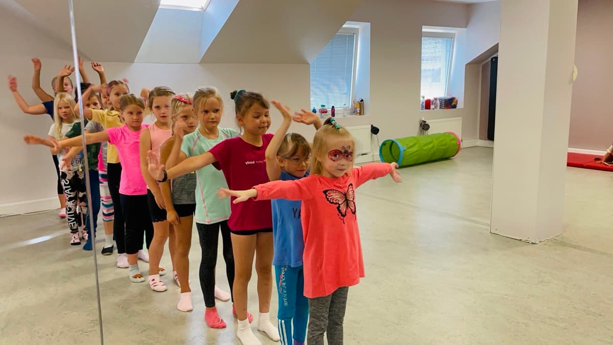 Lapsed saalis käed laiali harjutamas